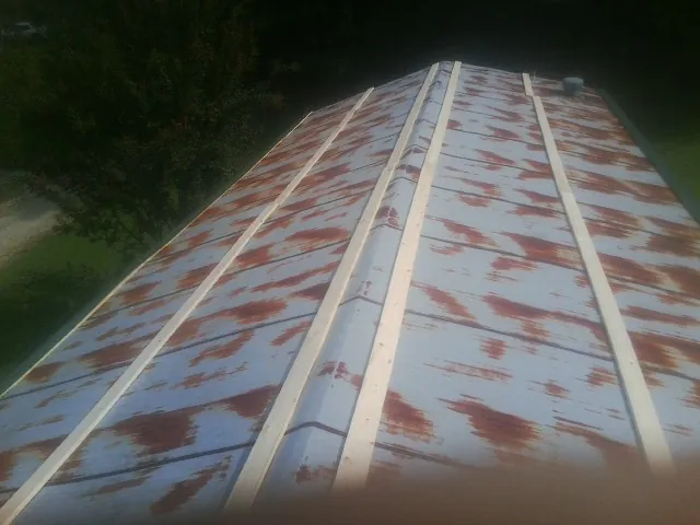 Rusted metal roof panels with new wood purlins before replacement — Storm Damage Roof Repair in Montauk by Roofing Brothers