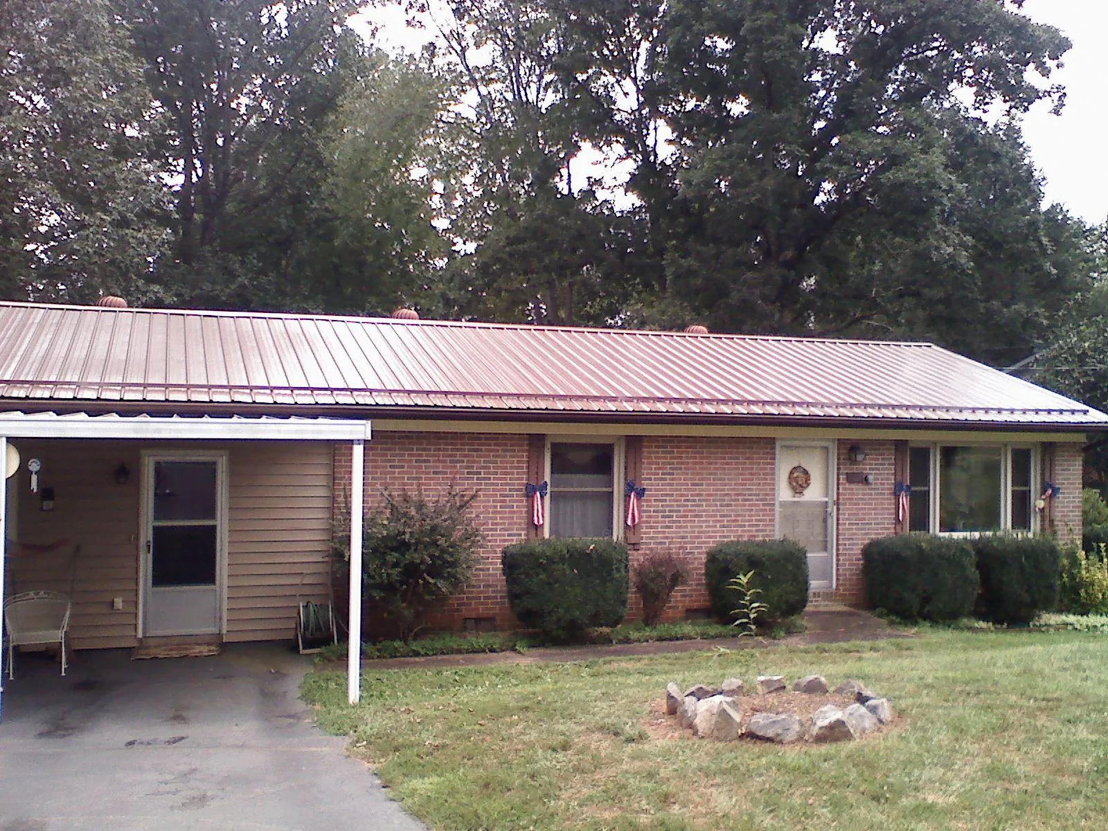 Bronze metal roof and carport on a brick ranch home — Roof Repair work by our crew in Montauk